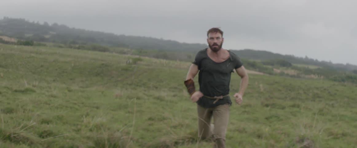 Man sprints across a grassy hilly field