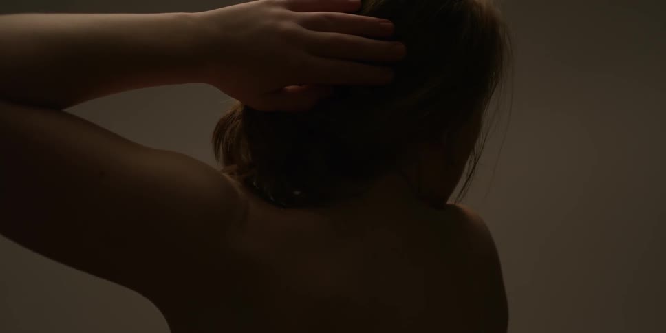 Topless woman moves her hand over her head