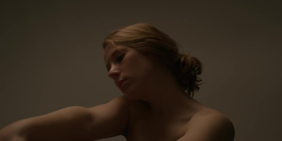 Woman rubs her bare shoulder and arm
