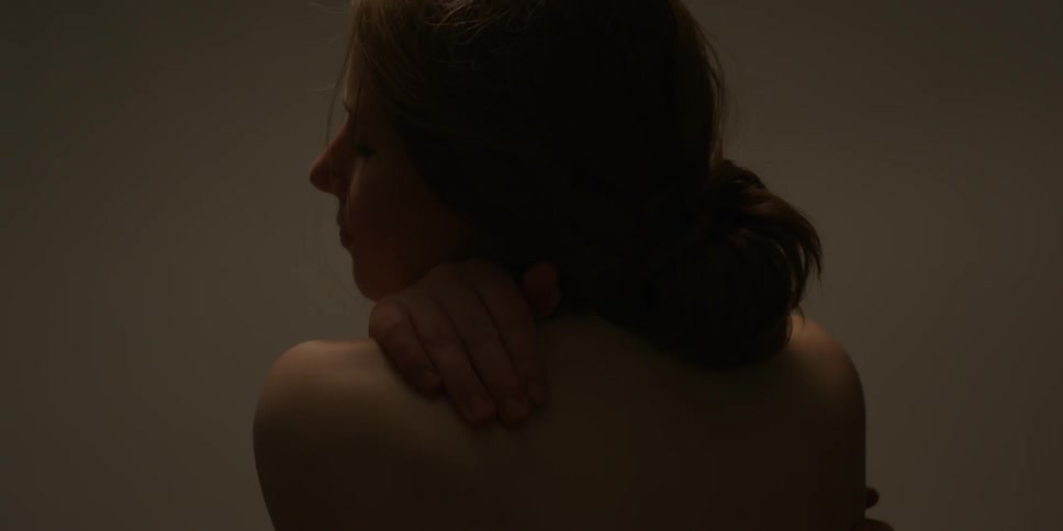 A naked woman is caressing her shoulders and back