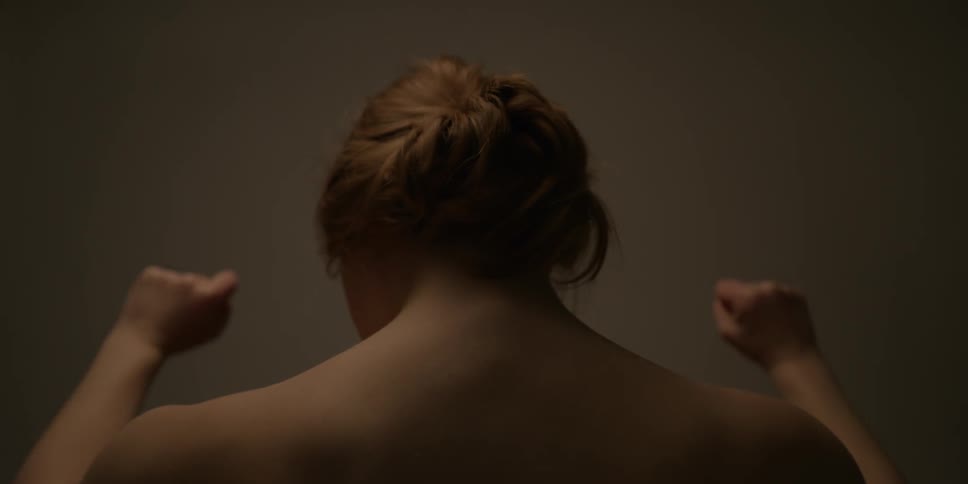 A woman clenches her firsts and raises them