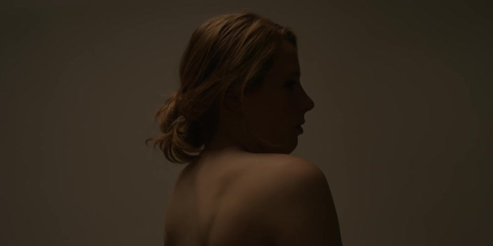 A woman slowly sits up rotating her shoulders and turning to the side