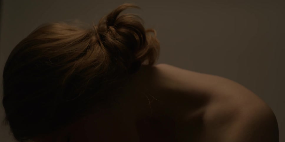 A woman is stretching in a dark room