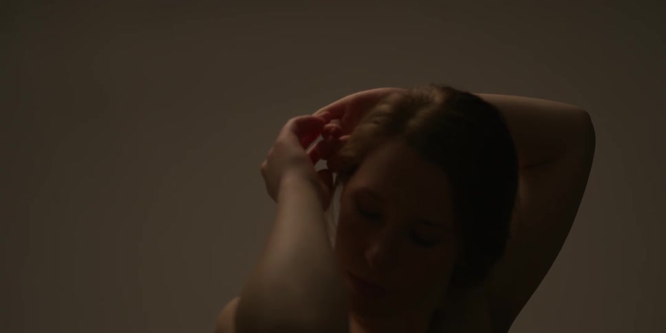 A woman raises her arms then lowers them behind her head