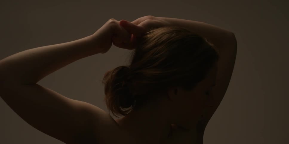 A woman holds her arms above her head and lowers them
