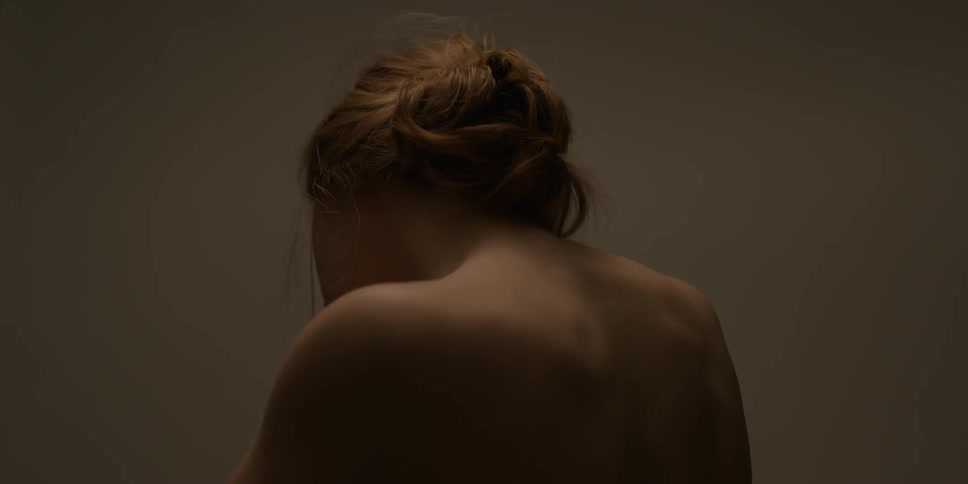 A naked woman shrugs her shoulders