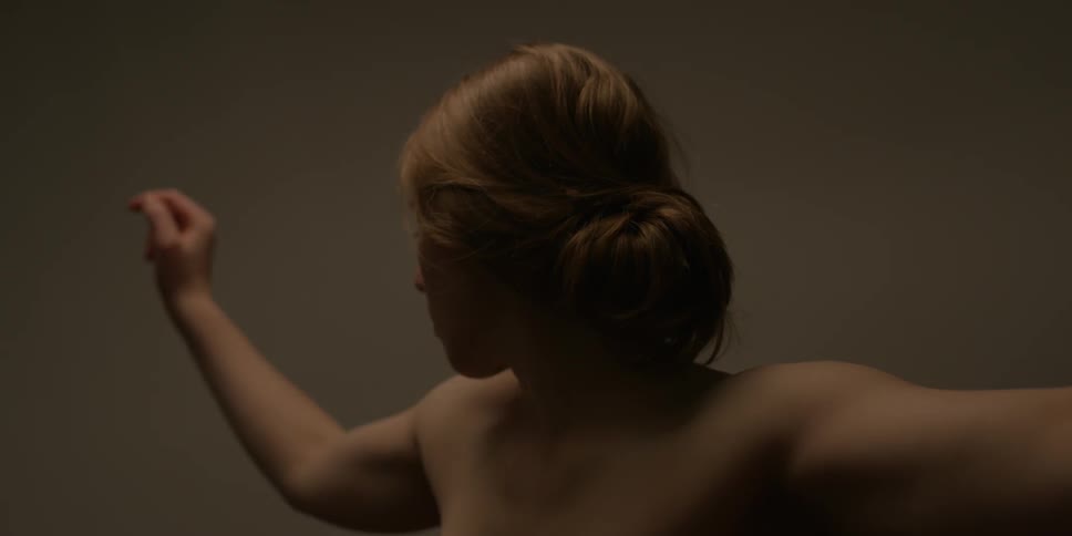 A woman raises her arms out
