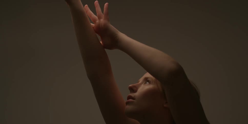 A woman raises her arm up rubbing it
