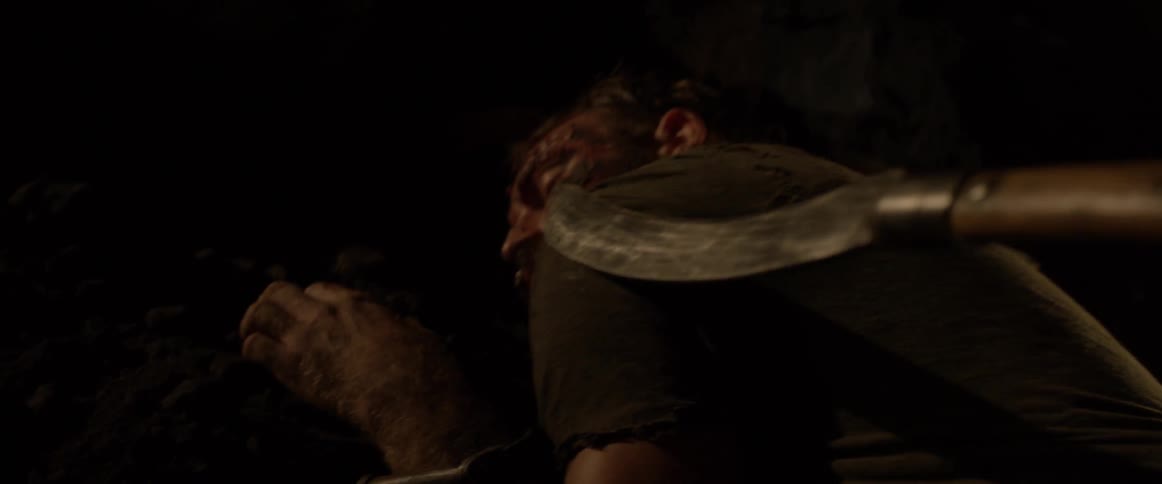 A long sharp knife pokes at an injured man