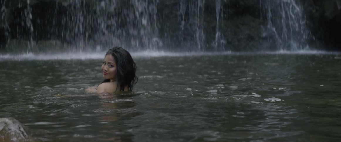 A woman is bathing in the waterfall spring