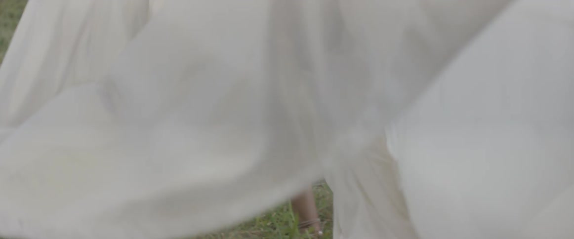 A woman's dress billows behind her as she runs