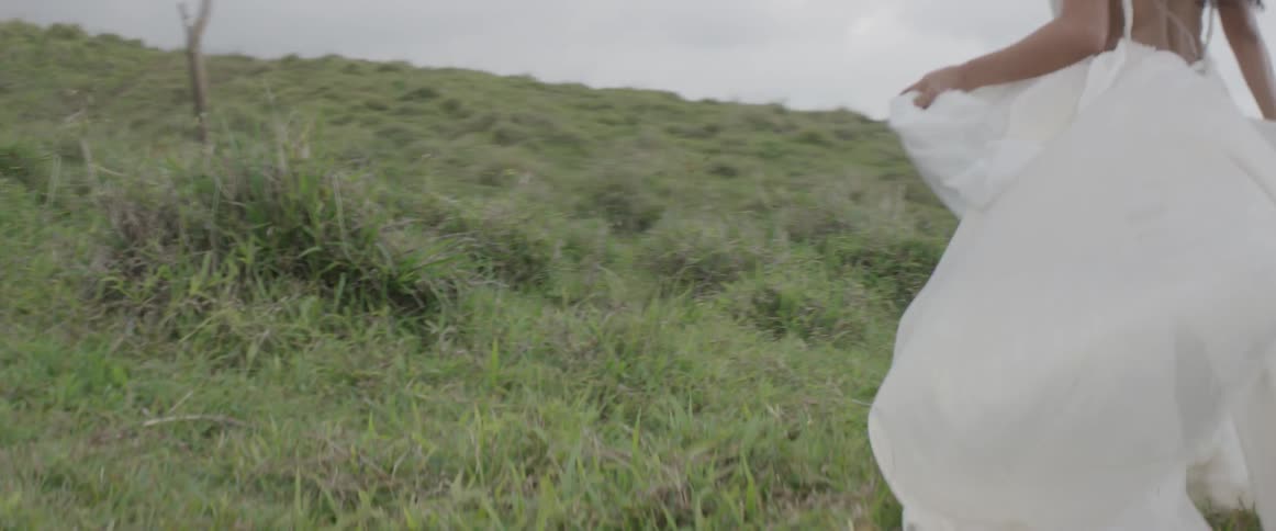 A woman in a white dress runs on the field