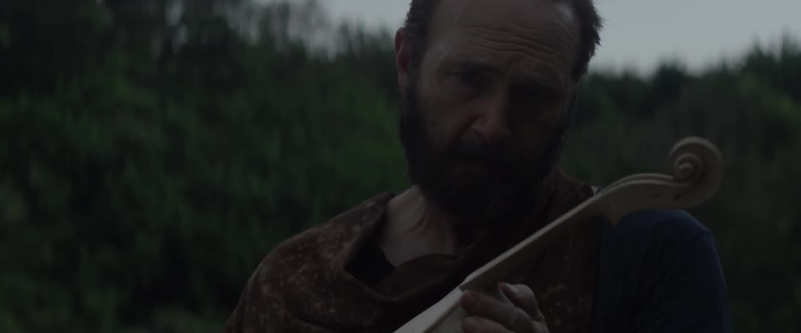 A man is holding an unfinished violin