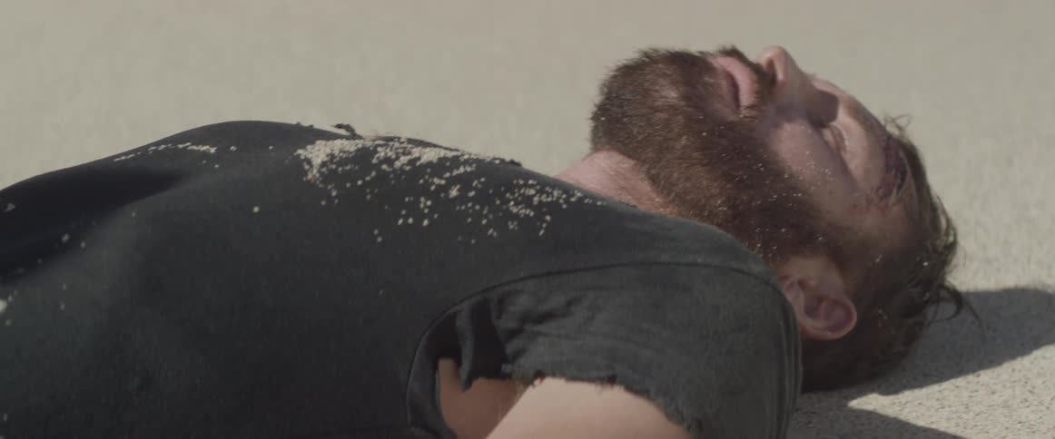 An unconscious man lies on a beach