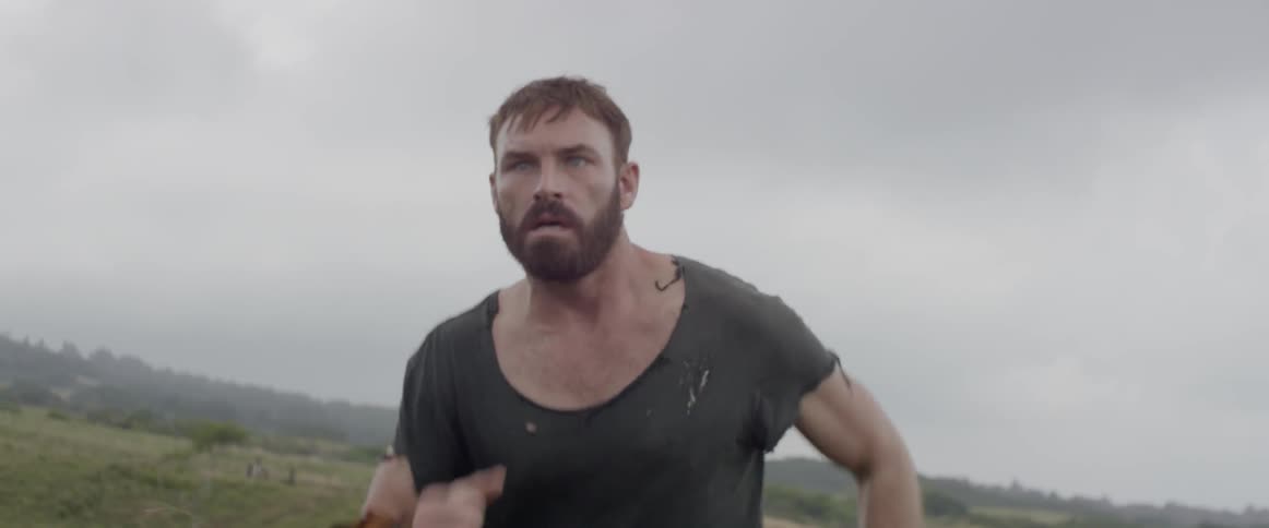 A man runs frantically through a field