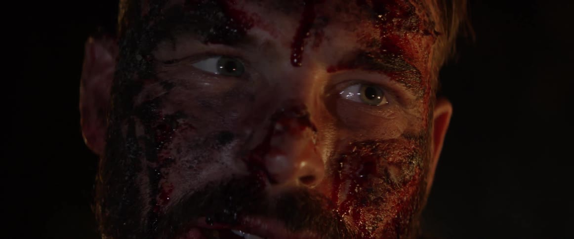 A man is bloody in a dark area