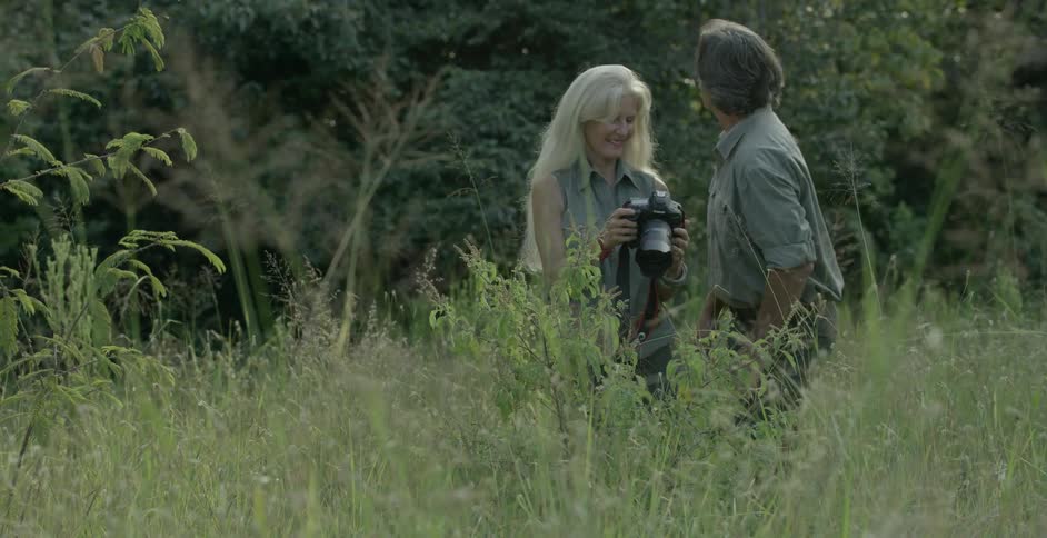 A woman shows a man a photograph on her camera