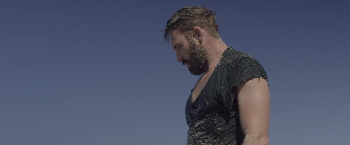 A man stands up slowly on a sunny day