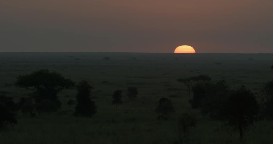 The sun slowly rises in the distance