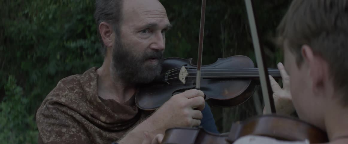 Two men hold and prepare to play violins