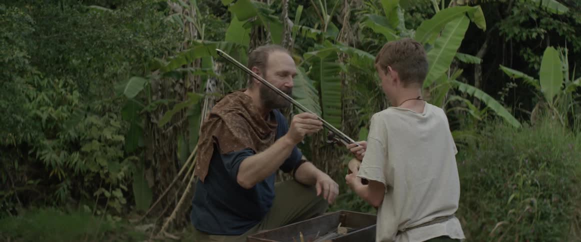 A man shows a boy how to play the violin