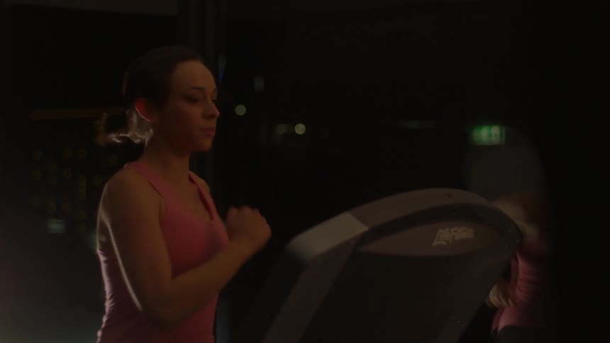 A woman jogs on a treadmill