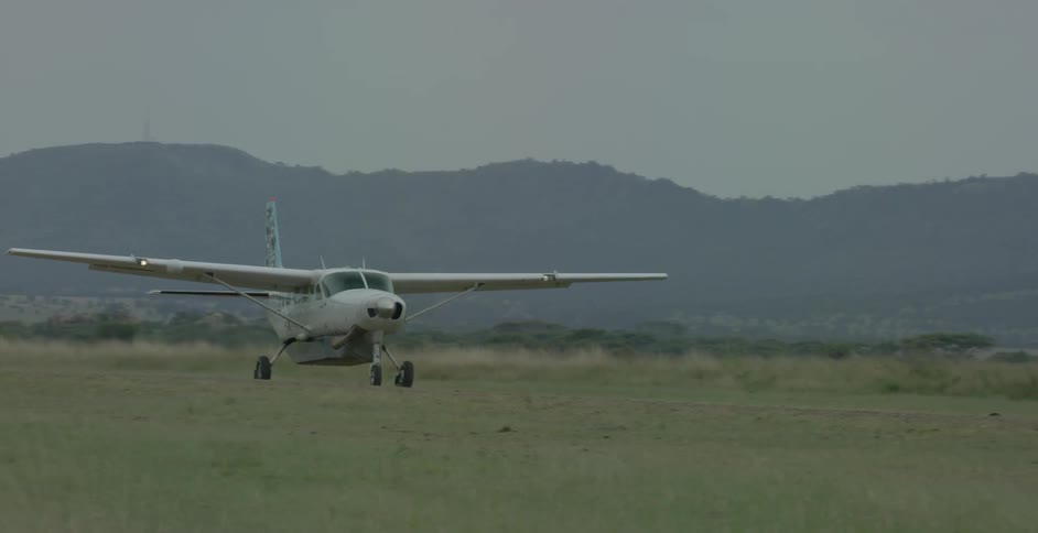 An airplane is moving along a runway in a field during the day