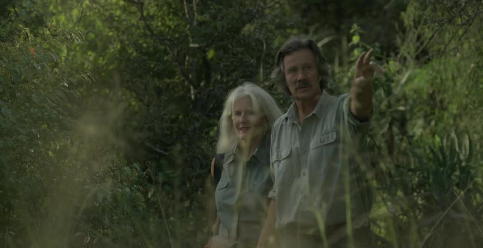 Man and woman hold hands as they walk through the woods