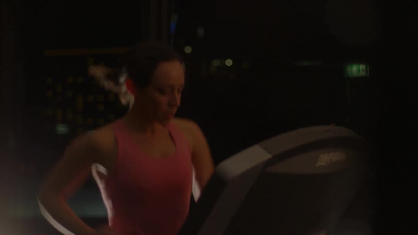 A woman is running on a treadmill