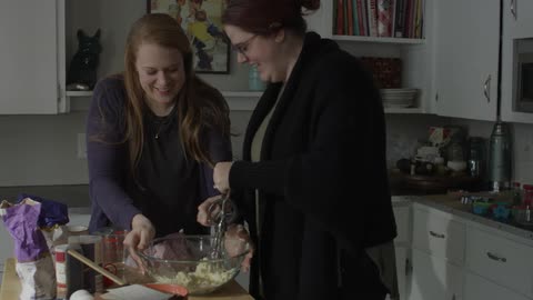 Two women are cooking in a kitchen