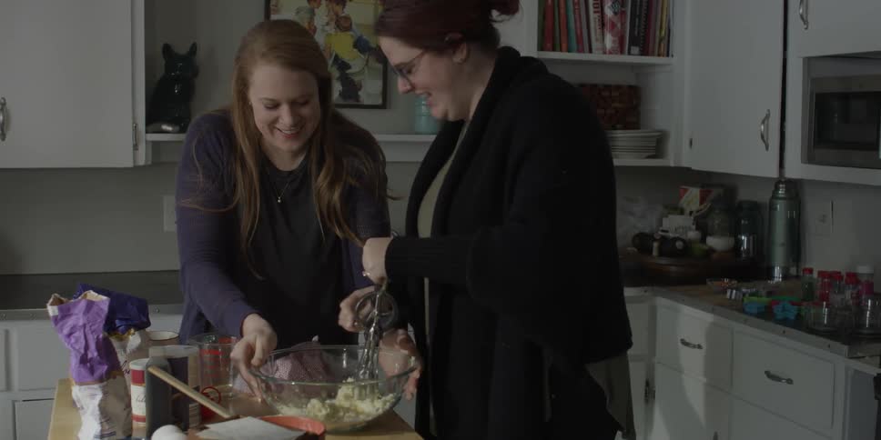 Two women are cooking in a kitchen
