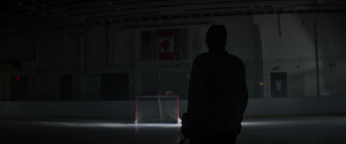 A hockey player skates on an indoor ice rink