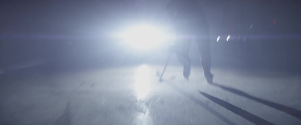 A hockey player is charging down the rink