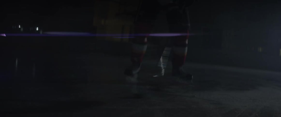 A hockey player hits a puck back and forth on an indoor ice rink