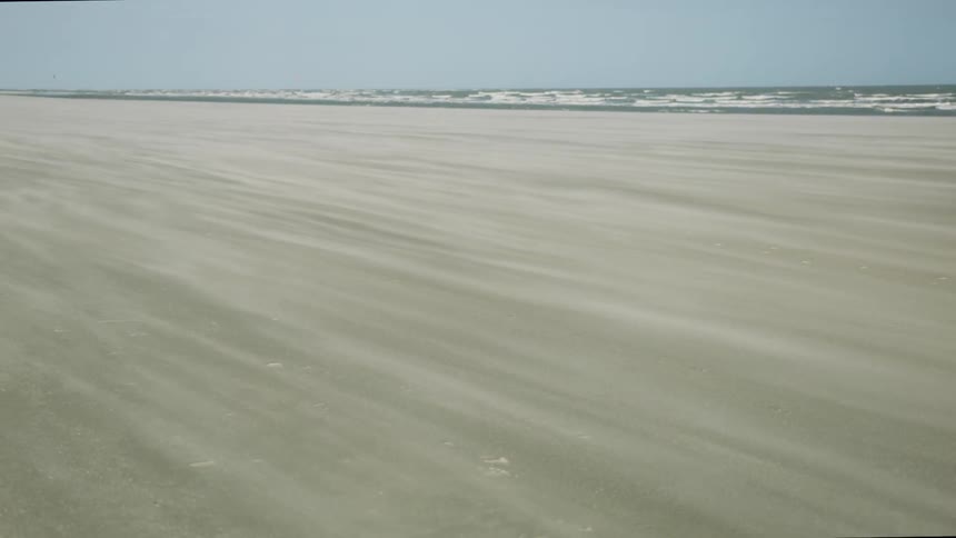 Sand is blowing around the beach