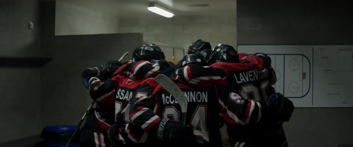 A hockey team huddles together in the locker room
