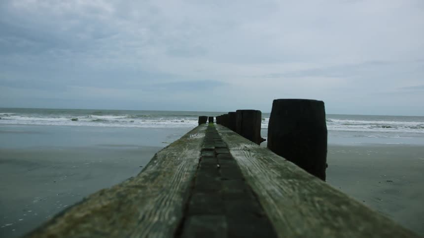An old dock leading out into a large body of water