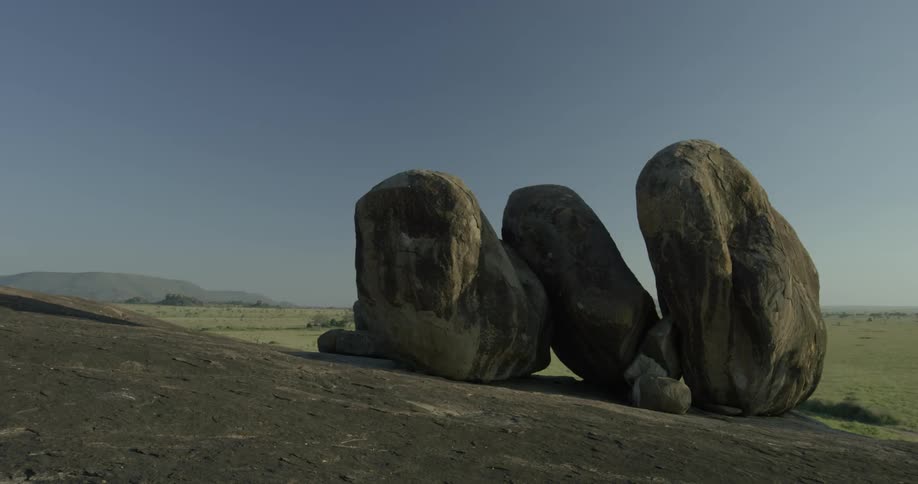 The field has large rocks on the field are on a hill