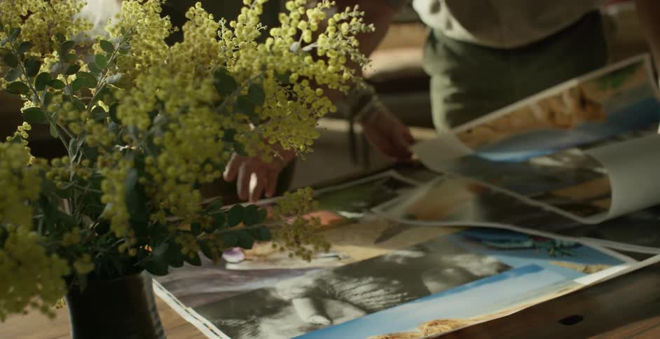 Two people look over high quality photographs on a table