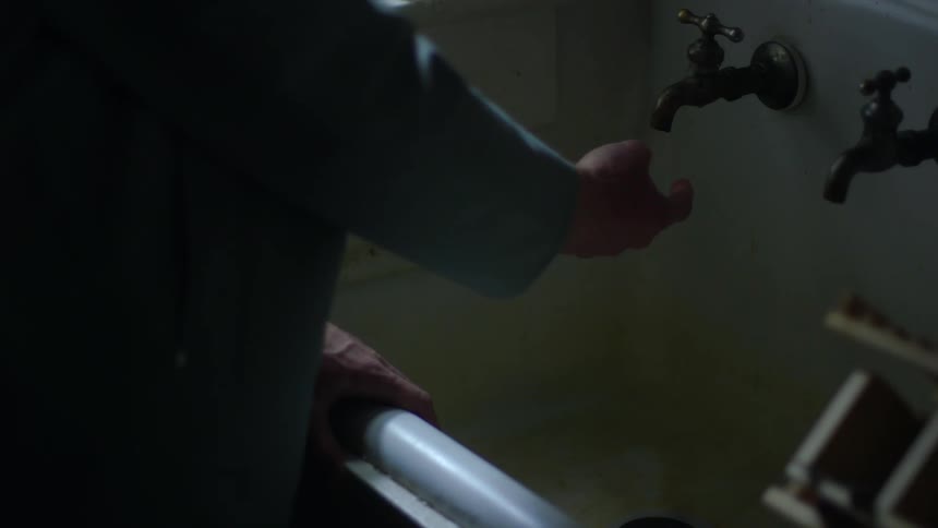 A person goes to use the sink