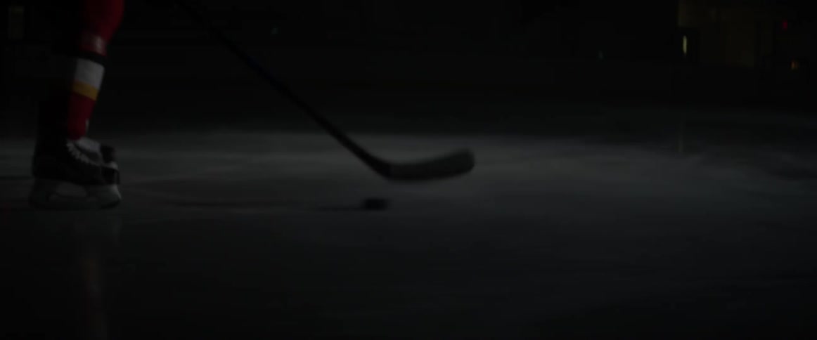A person is driving the puck down the ice rink