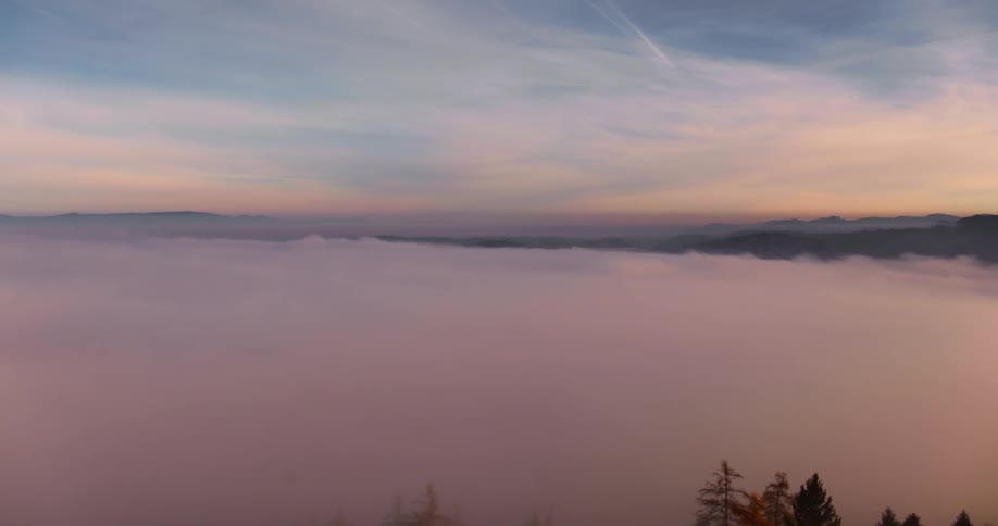 A drone is filming a fog covered valley
