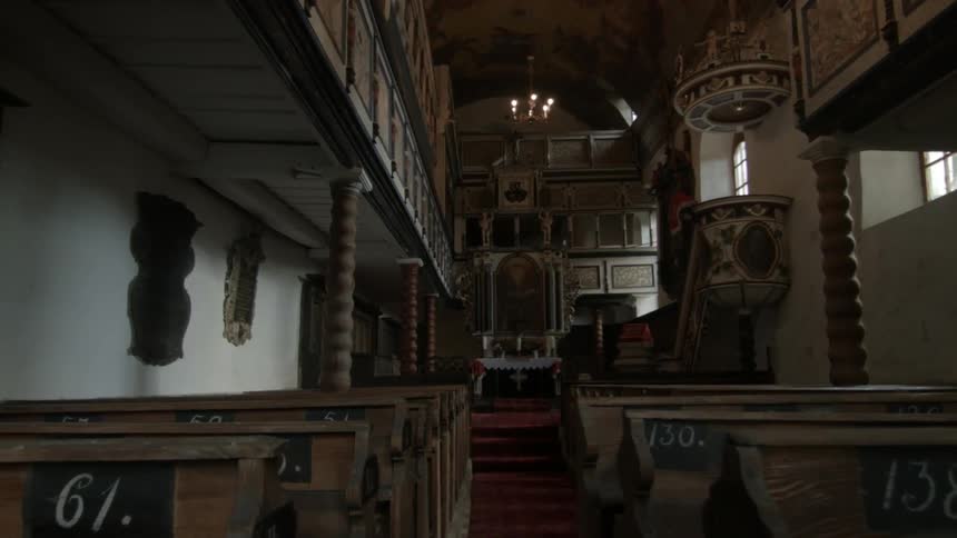 Church pews line each side of the aisle in a church