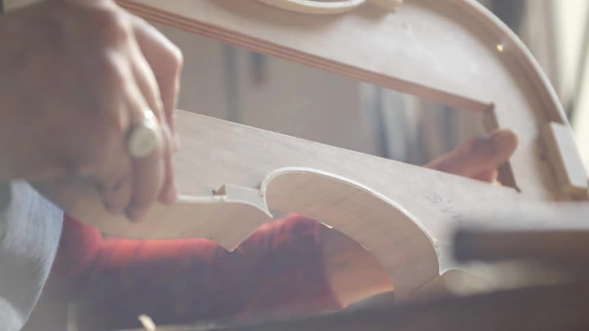 Person making a violin on a sunny day