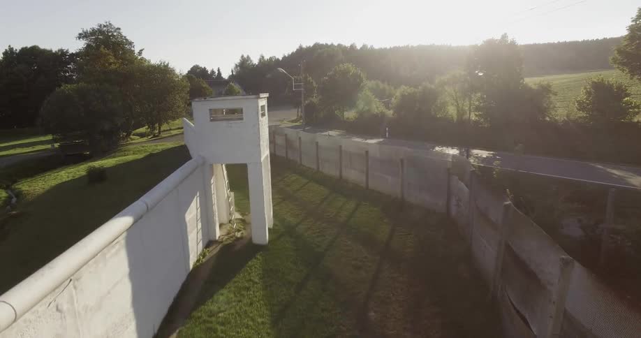 The grass is surrounded by a long fence