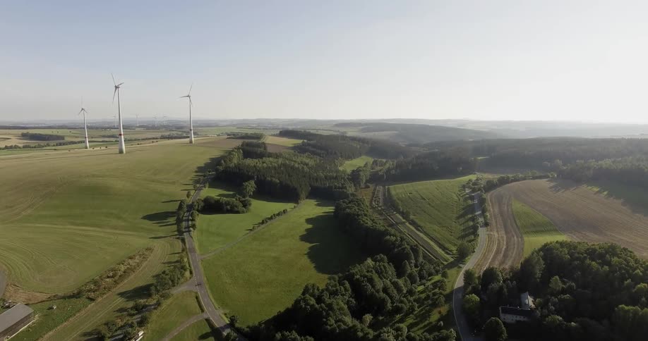 Wind turbines stand in a grassy field