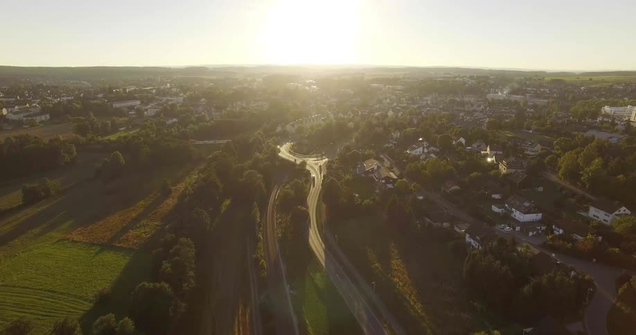 The sun is rising over the town below