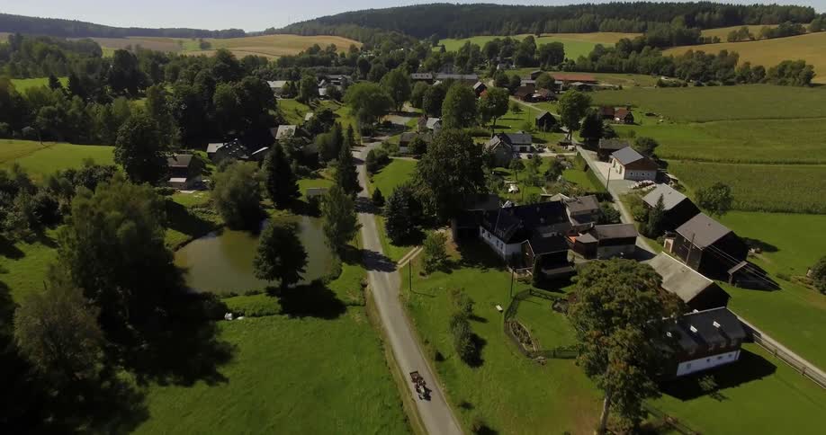 A drone is filming a green countryside village
