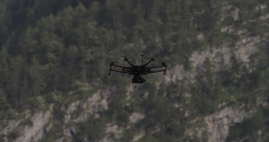 A drone is flying over a forest on a sunny day