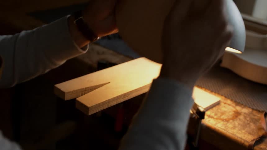 A man crafts a violin by hand